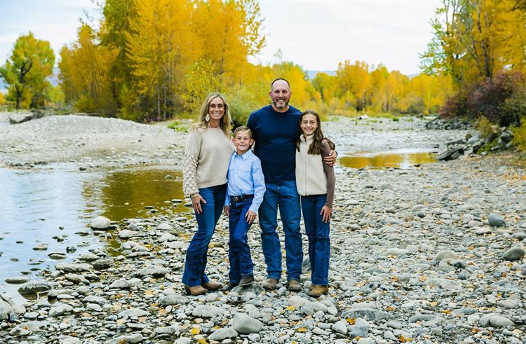 family standing in front of river